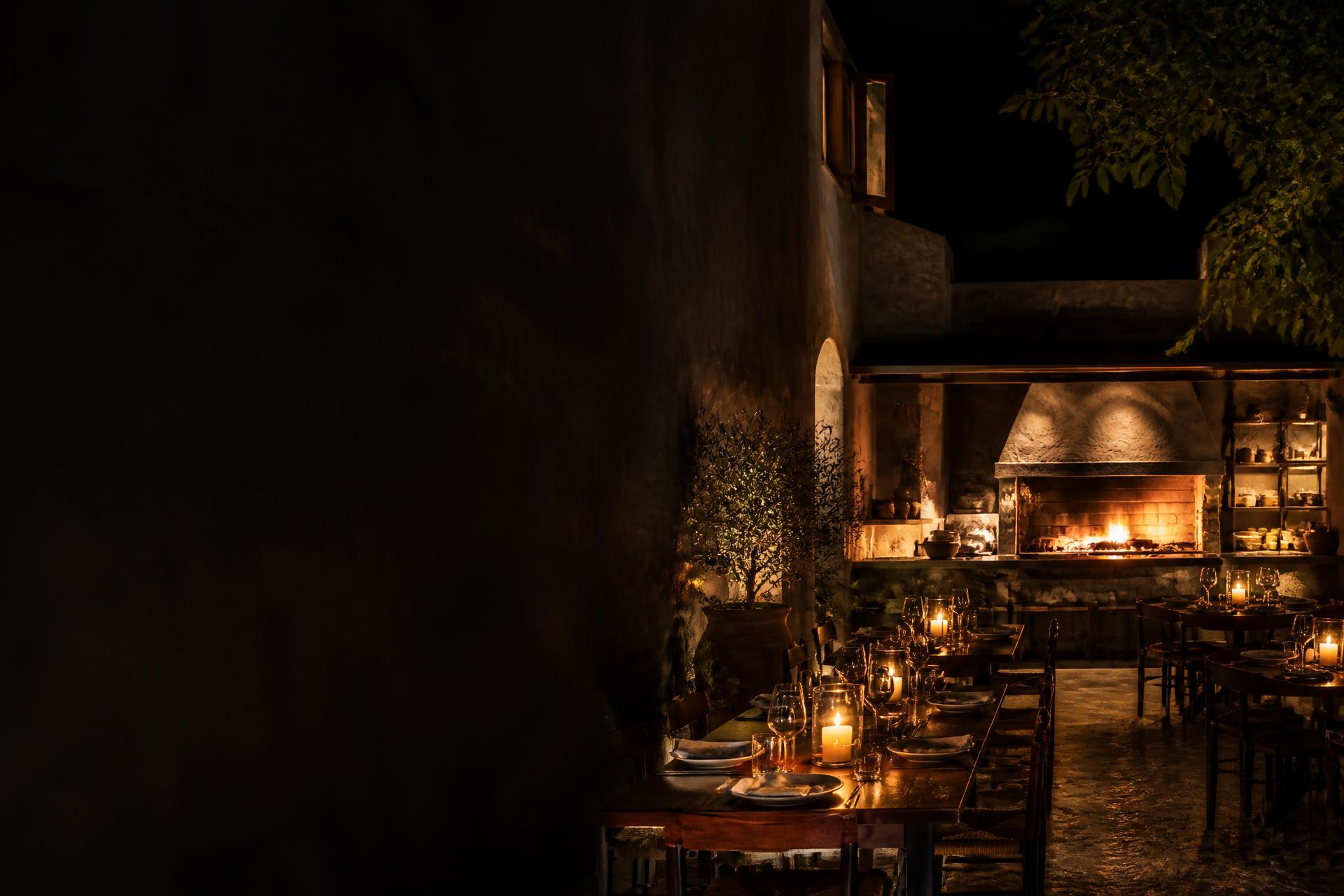 Comedor nocturno de SOHO Fire & Grill iluminado por velas y por la brasa